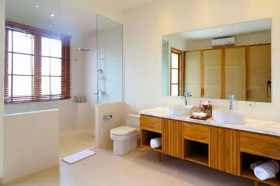 a bathroom with two sinks and a large mirror at Nawasena 5 BR Private Pool Villa in Canggu