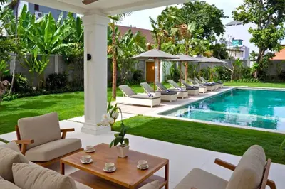 a patio with chairs and a swimming pool at Nawasena 5 BR Private Pool Villa in Canggu