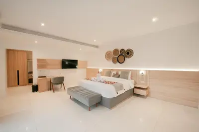 a bedroom with a bed and a table and a chair at Seminyak Villa Luxury 4BR near Beach Lafavela in Seminyak