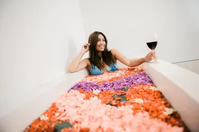a woman holding a glass of wine in a box of confetti at Seminyak Villa Luxury 4BR near Beach Lafavela in Seminyak