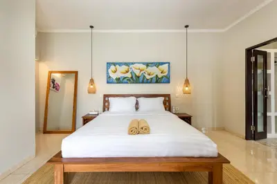 a bedroom with a bed with two flip flops on it at Villa Raja Seminyak by KING in Seminyak