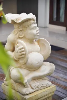a statue of a woman sitting on a porch at Villa Raja Seminyak by KING in Seminyak