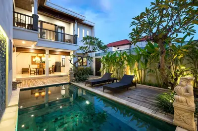 a villa with a swimming pool and a house at Villa Raja Seminyak by KING in Seminyak