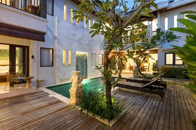 a courtyard with a swimming pool and a tree at Villa Raja Seminyak by KING in Seminyak