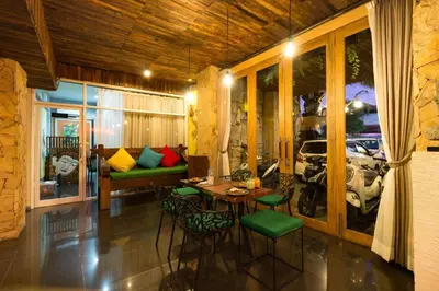 a room with a table and chairs and a couch at Hadi Poetra Hotel in Kuta