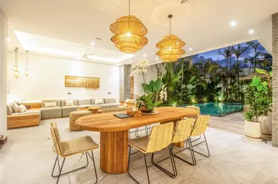 a living room with a wooden table and chairs at Coastal Elegance 4BR Villa, 400m to Finns in Canggu