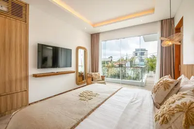 a bedroom with a large bed and a tv at Coastal Elegance 4BR Villa, 400m to Finns in Canggu