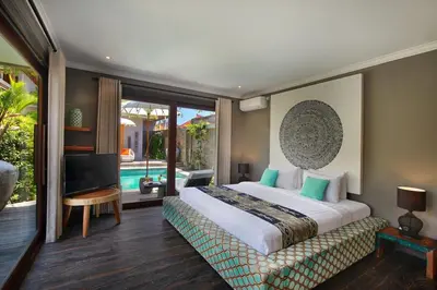 a bedroom with a large bed and a pool at Villa Gahana Bali in Seminyak