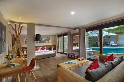 a living room with a couch and a swimming pool at Villa Gahana Bali in Seminyak