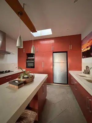 a kitchen with red cabinets and a door with a counter at Villa Jepun in Canggu
