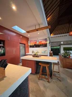 a kitchen with red cabinets and a white counter top at Villa Jepun in Canggu