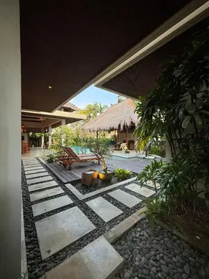 an outside view of a house with a courtyard with a bench at Villa Jepun in Canggu