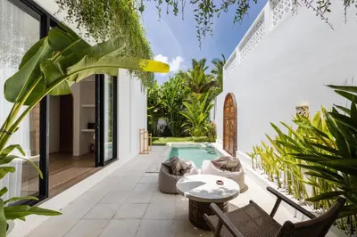 an outdoor patio with a swimming pool and plants at New Villa Manis proche Seminyak in Seminyak