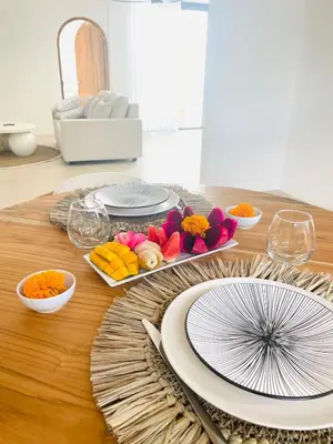 a table with plates and bowls of food on it at New Villa Manis proche Seminyak in Seminyak