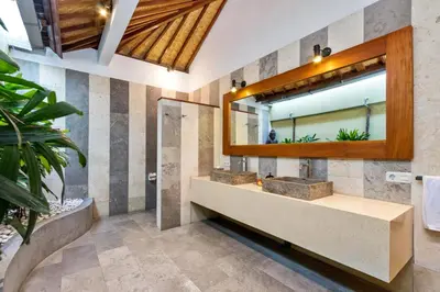 a bathroom with two sinks and a mirror at Villa Shantika by Villa Finder in Seminyak