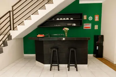 a bar with two stools and a green wall at Villa Majapahit Kuta 5 bedrooms in Legian