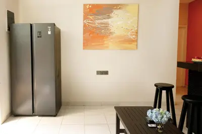 a stainless steel refrigerator in a kitchen with a table at Villa Majapahit Kuta 5 bedrooms in Legian
