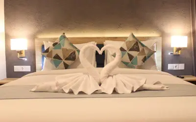 two swans made out of towels on a bed at Anagata Paradiso Bali in Nusa Dua