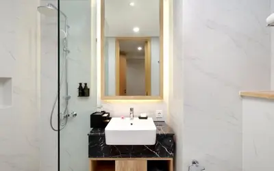 a bathroom with a white sink and a mirror at Anagata Paradiso Bali in Nusa Dua