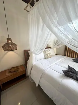 a bedroom with a white bed with a canopy at Villa CUCU - Legian - 3 Bedroom in Legian