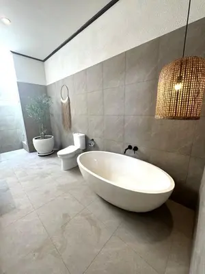 a bathroom with a large white tub and a toilet at Villa CUCU - Legian - 3 Bedroom in Legian