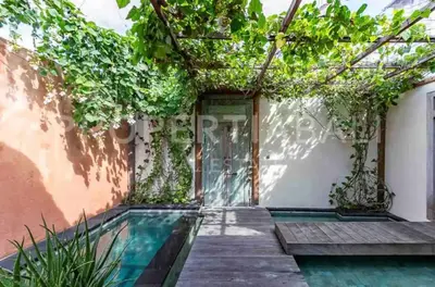 a house with a swimming pool next to a building at Villa Pisces - 2 Bedrooms Villa with Private Pool at Kerobokan in Denpasar