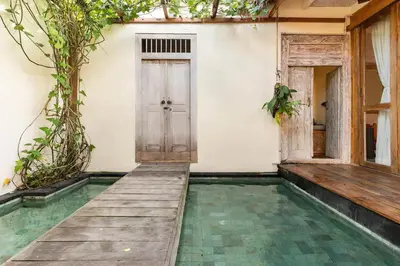 a house with a swimming pool and a door at Villa Pisces - 2 Bedrooms Villa with Private Pool at Kerobokan in Denpasar