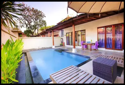 a swimming pool in a backyard with a table and chairs at One Bedroom Private Pool Classic Villa in Kuta