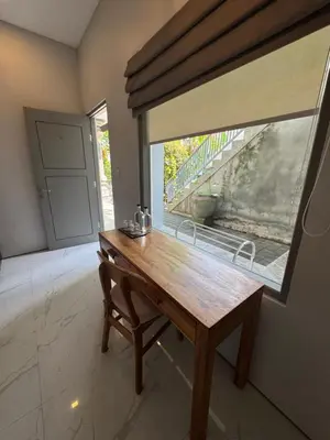 a wooden table in a room with a window at Aleenka House in Canggu