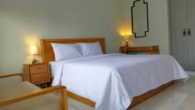 a bedroom with a large white bed with two night stands at Aleenka House in Canggu