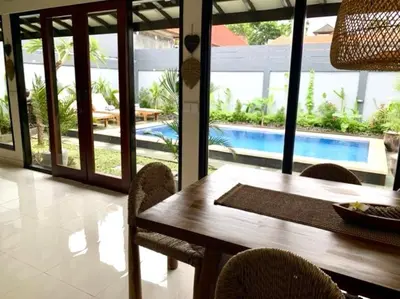 a dining room with a table and chairs and a pool at Villa VALARI - Seminyak Legian - 5 Bedrooms in Seminyak