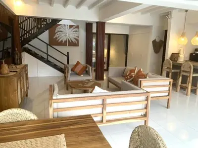a living room filled with furniture and a staircase at Villa VALARI - Seminyak Legian - 5 Bedrooms in Seminyak