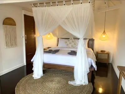 a bedroom with a canopy bed with white curtains at Villa VALARI - Seminyak Legian - 5 Bedrooms in Seminyak