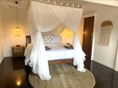 a bedroom with a white bed with mosquito nets at Villa VALARI - Seminyak Legian - 5 Bedrooms in Seminyak