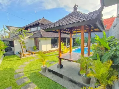 a garden with a wooden gazebo and a pool at Villa VALARI - Seminyak Legian - 5 Bedrooms in Seminyak