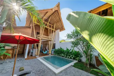 a villa with a swimming pool and a house at The Secret Jungle Villas Seminyak in Seminyak