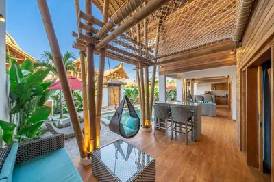an outdoor patio with a swing and a table and chairs at The Secret Jungle Villas Seminyak in Seminyak