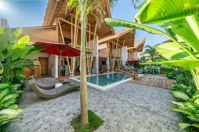 an exterior view of a house with a swimming pool at The Secret Jungle Villas Seminyak in Seminyak