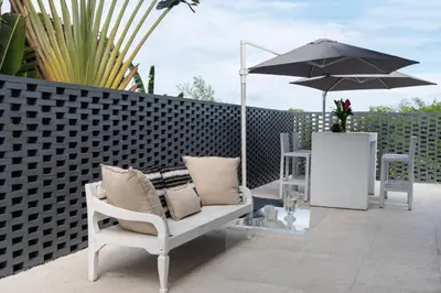 a patio with a chair and an umbrella at Villa Manis Cantik in Seminyak