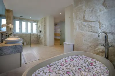 a bathroom with a bath tub filled with pink flowers at Villa Manis Cantik in Seminyak