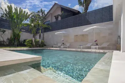a swimming pool in front of a house at Villa Manis Cantik in Seminyak