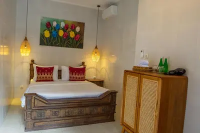 a bedroom with a bed and a painting of flowers at Atres Griya Villa 5 Private Bedroom Kuta in Kuta