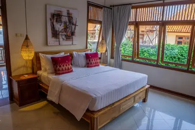 a bedroom with a large bed with red pillows at Atres Griya Villa 5 Private Bedroom Kuta in Kuta