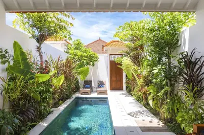 a pool in the backyard of a house with plants at Villa Nook in Seminyak