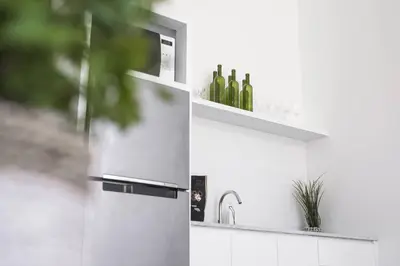 a kitchen with a sink with wine bottles on a shelf at Villa Nook in Seminyak