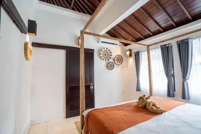 a bedroom with a bed with a teddy bear on it at Villa Coconut Heaven by Bali Villa Solutions in Seminyak