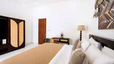 a bedroom with a bed and a table at Villa Latima by Villa Finder in Seminyak