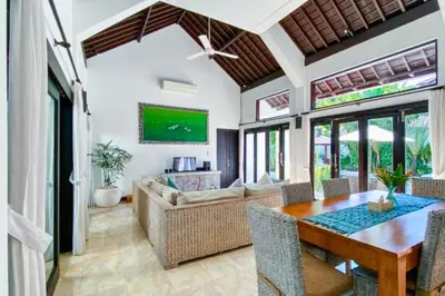 a dining room with a table and a couch at Chetana 2 BR Private Pool Villa in Ujung