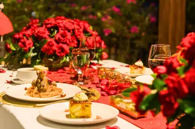 a table topped with plates of food and red flowers at Charvi 1 BR Private Pool Villa in Ujung