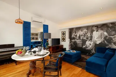 a living room with a table and blue furniture at Shanti Estate Seminyak by Nakula in Seminyak